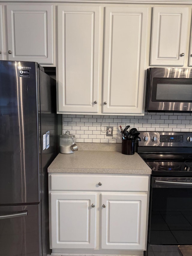 101 Cobblers Glen Ct, Lexington, SC 29072 - kitchen featuring black electric range oven, freestanding refrigerator, stainless steel microwave, and white cabinets