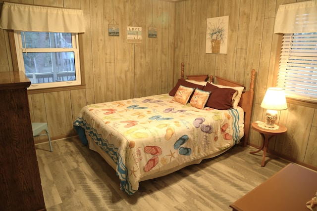 bedroom with wooden walls and hardwood / wood-style floors