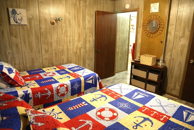 bedroom featuring wooden walls