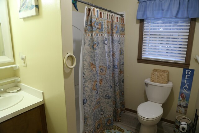 bathroom featuring vanity, curtained shower, and toilet