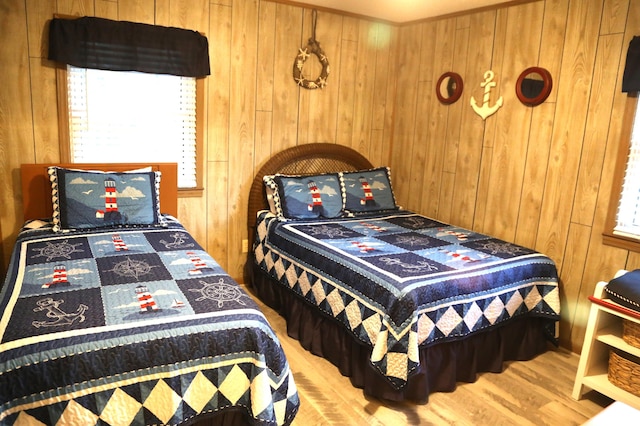 bedroom with hardwood / wood-style floors, multiple windows, and wood walls