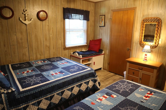 bedroom with wooden walls and light hardwood / wood-style floors