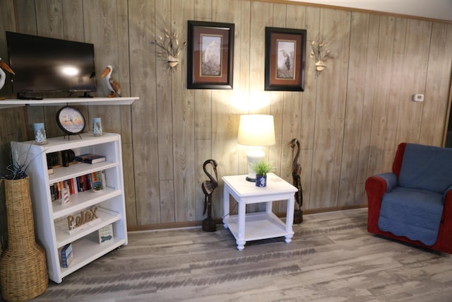 living area with wood-type flooring and wooden walls