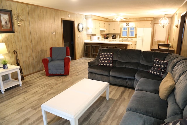 living room with light wood-type flooring and wood walls