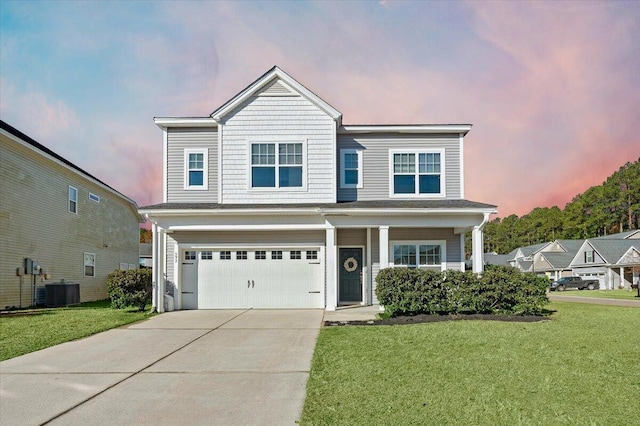 view of front of house featuring a yard, cooling unit, and a garage