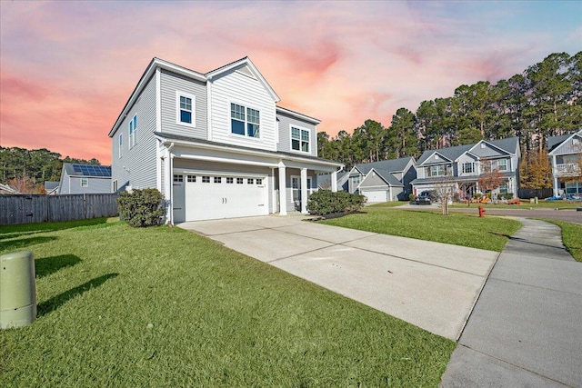 view of front of property featuring a garage and a lawn