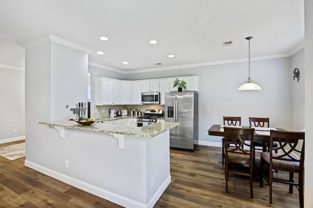 kitchen featuring white cabinetry, hanging light fixtures, tasteful backsplash, kitchen peninsula, and appliances with stainless steel finishes