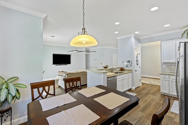 dining area featuring hardwood / wood-style flooring, ceiling fan, sink, and crown molding