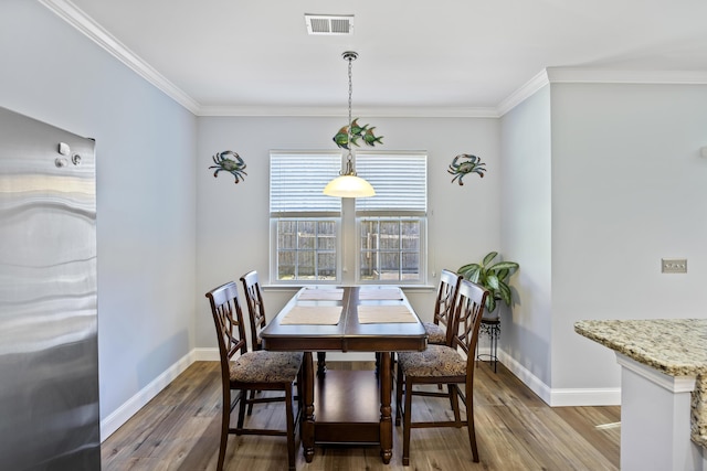 dining area featuring dark hardwood / wood-style flooring and ornamental molding