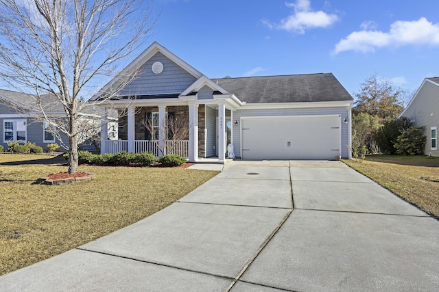 view of front of house featuring a garage, covered porch, and a front lawn