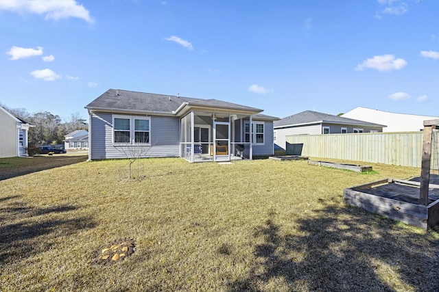 back of property with a sunroom and a lawn