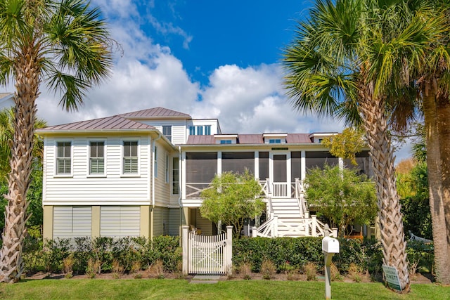 rear view of property featuring a sunroom