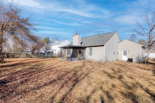 rear view of house with a yard and a sunroom