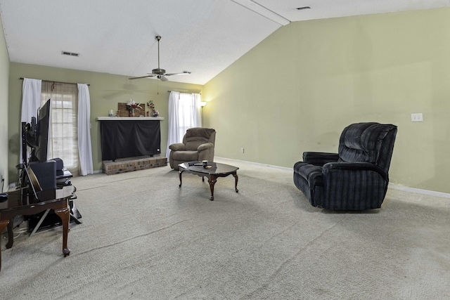 living area with lofted ceiling, ceiling fan, and carpet flooring