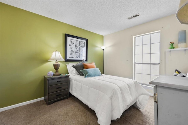 carpeted bedroom featuring visible vents, a textured ceiling, and baseboards