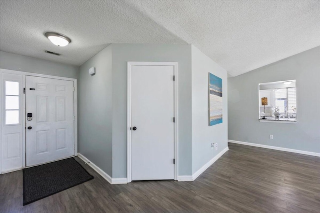 entryway with dark wood-style flooring, lofted ceiling, visible vents, a textured ceiling, and baseboards