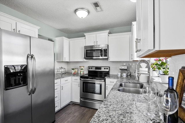 kitchen featuring white cabinetry, appliances with stainless steel finishes, and backsplash