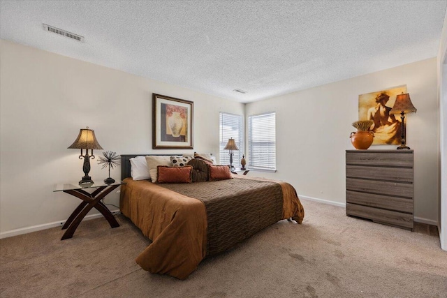 carpeted bedroom with a textured ceiling, visible vents, and baseboards