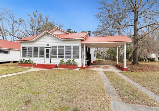 222 E Main St, Moncks Corner, SC 29461 - view of front of home with driveway, a front lawn, an attached carport, and metal roof