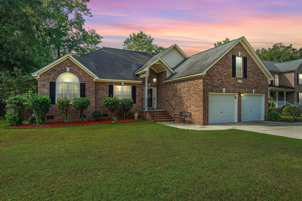 view of front of property featuring a yard and a garage