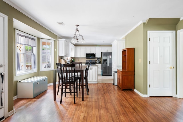 103 Retriever Ln, Goose Creek, SC 29445 - dining area with light wood-type flooring, a chandelier, crown molding, and baseboards