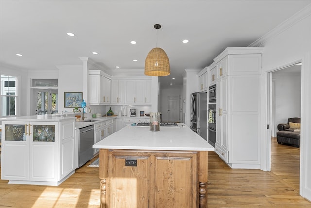228 Beresford Creek St, Charleston, SC 29492 - kitchen with stainless steel appliances, light wood-style floors, a peninsula, white cabinets, and crown molding