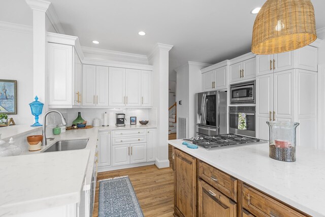 228 Beresford Creek St, Charleston, SC 29492 - kitchen featuring appliances with stainless steel finishes, white cabinets, light wood-style floors, tasteful backsplash, and crown molding