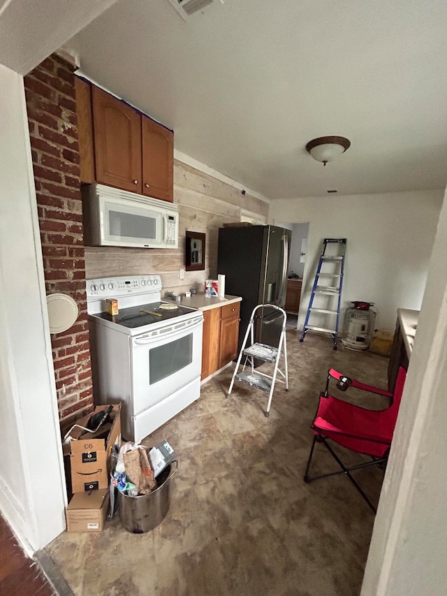 kitchen featuring wooden walls and white appliances