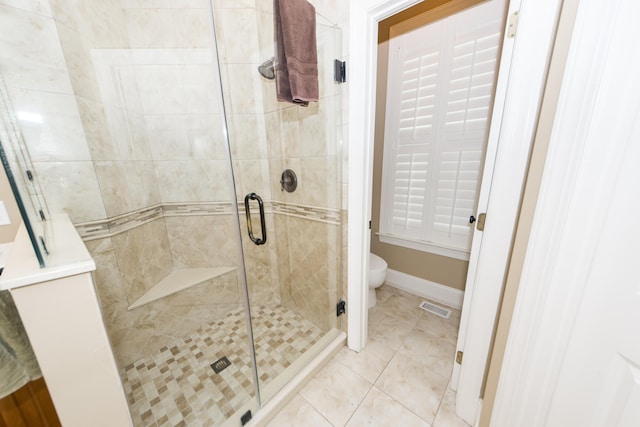 bathroom with toilet, tile patterned floors, and a shower with shower door