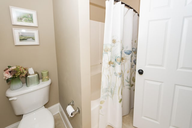 bathroom featuring tile patterned floors, shower / bath combination with curtain, and toilet