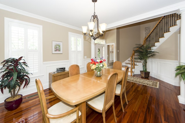 dining room featuring an inviting chandelier, crown molding, and dark wood-type flooring