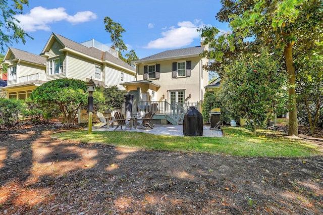 rear view of house with a patio and stucco siding