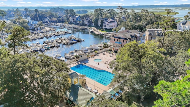 aerial view of a marina, a nearby body of water, and a pool