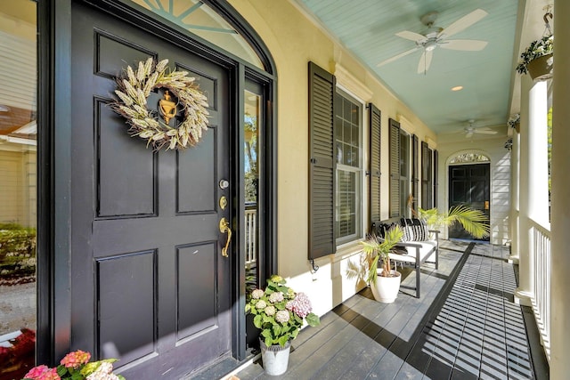 view of exterior entry with covered porch and a ceiling fan