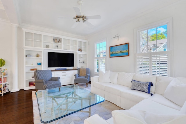 living room with plenty of natural light, ceiling fan, wood finished floors, ornamental molding, and built in shelves
