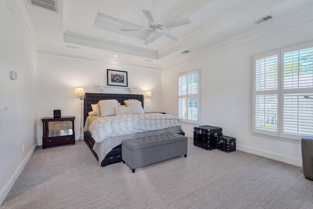 bedroom with multiple windows, carpet floors, a raised ceiling, ornamental molding, and baseboards