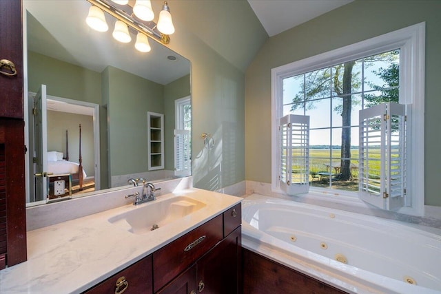 bathroom with vanity, a tub to relax in, and vaulted ceiling