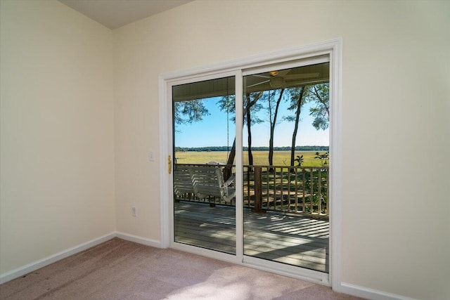 entryway featuring light carpet and a rural view