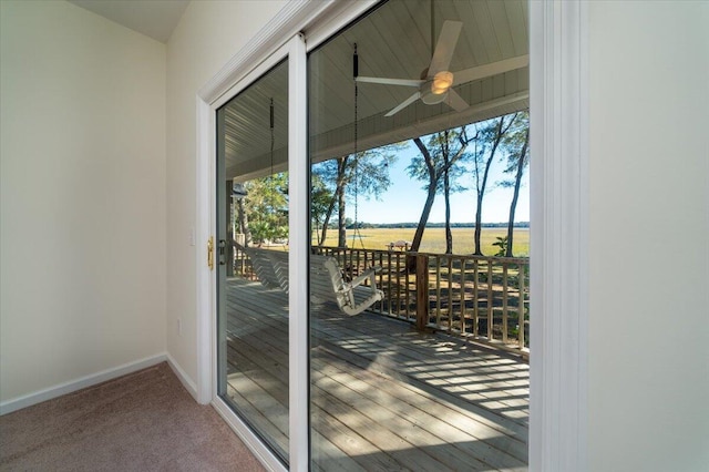 entryway with carpet flooring, a rural view, a wealth of natural light, and ceiling fan