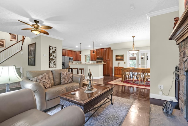 2494 Cape Rd, Johns Island, SC 29455 - living room with ceiling fan, a stone fireplace, dark wood-type flooring, a textured ceiling, and stairs
