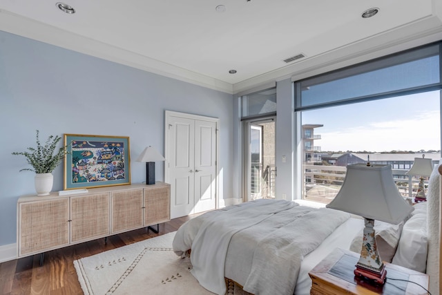 bedroom with ornamental molding, dark wood-type flooring, access to exterior, and a closet
