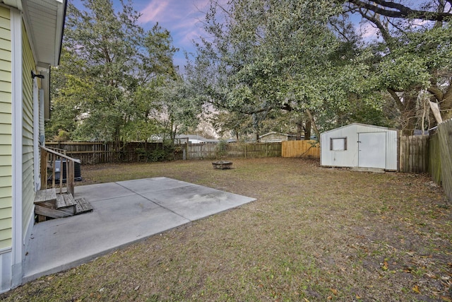 yard at dusk featuring a patio area and a fire pit