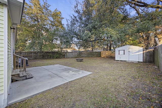 view of yard featuring a patio, an outdoor fire pit, and a storage unit