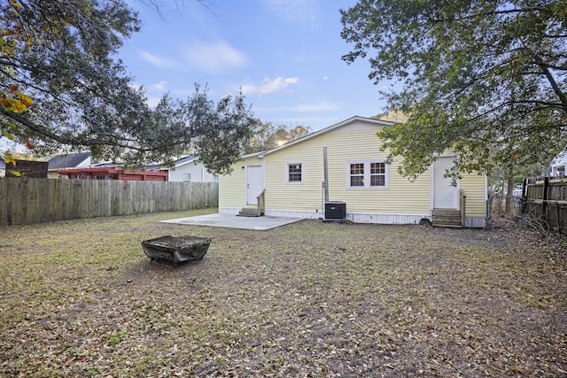 rear view of property with cooling unit and a patio