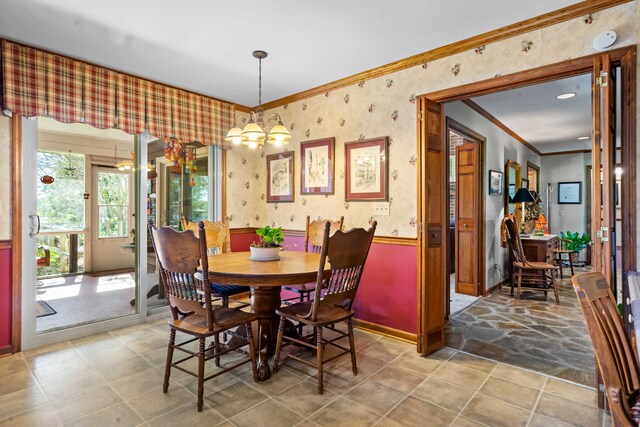 dining room with crown molding and a chandelier