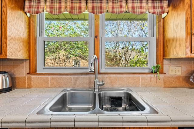 kitchen featuring decorative backsplash, sink, and tile countertops