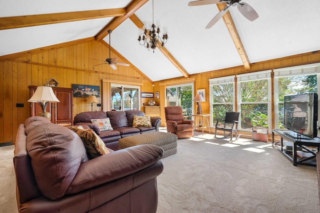 living room with wood walls, beam ceiling, ceiling fan, and light carpet