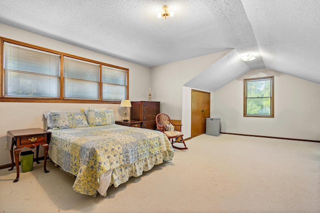 carpeted bedroom with a textured ceiling and lofted ceiling