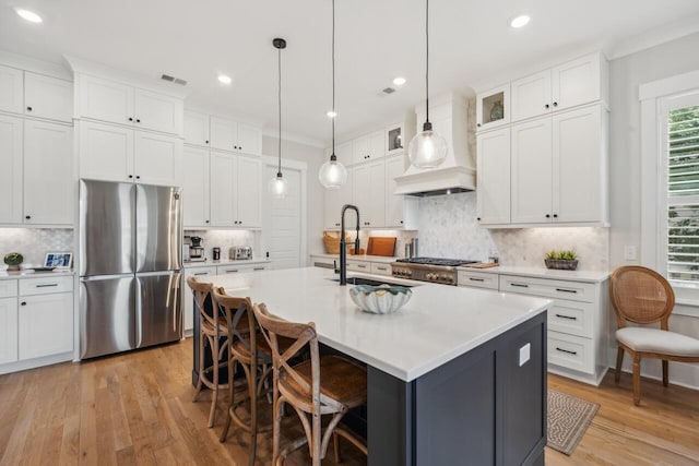 1903 Bolden Dr, Mount Pleasant, SC 29466 - kitchen featuring freestanding refrigerator, white cabinetry, light wood-style flooring, a kitchen bar, and light countertops