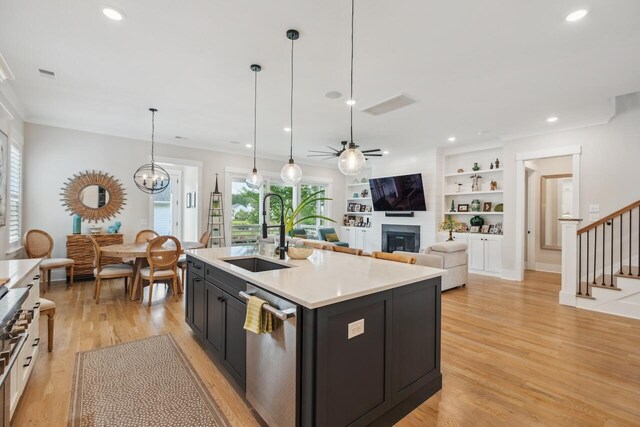 1903 Bolden Dr, Mount Pleasant, SC 29466 - kitchen featuring stainless steel dishwasher, a glass covered fireplace, light wood-style flooring, light countertops, and recessed lighting